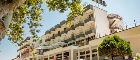 A hotel with multiple balconies, a clear sky, and a sign that reads "HOTEL".