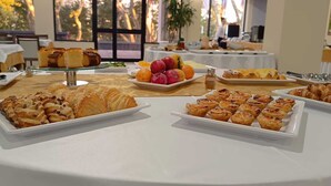 Una mesa de buffet con diversos pasteles y frutas.