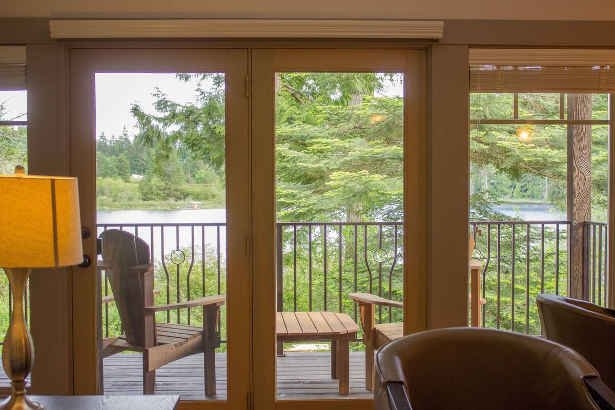 A room with a wooden deck, a table, and two chairs.