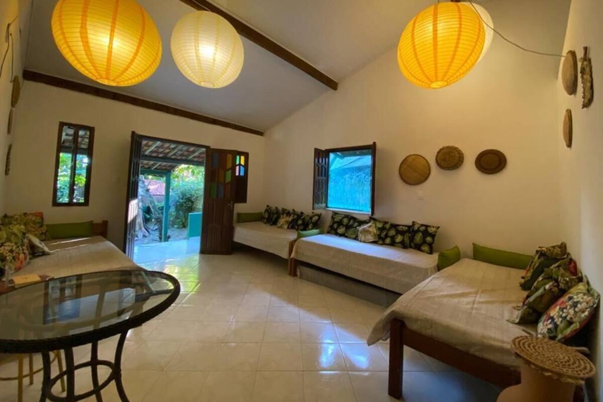 A room with a glass table, two sofas, and a television.