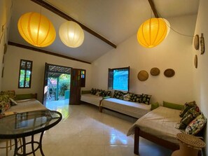 A room with a glass table, two sofas, and a television. - Pousada Sossego Boipeba (Cairu)
