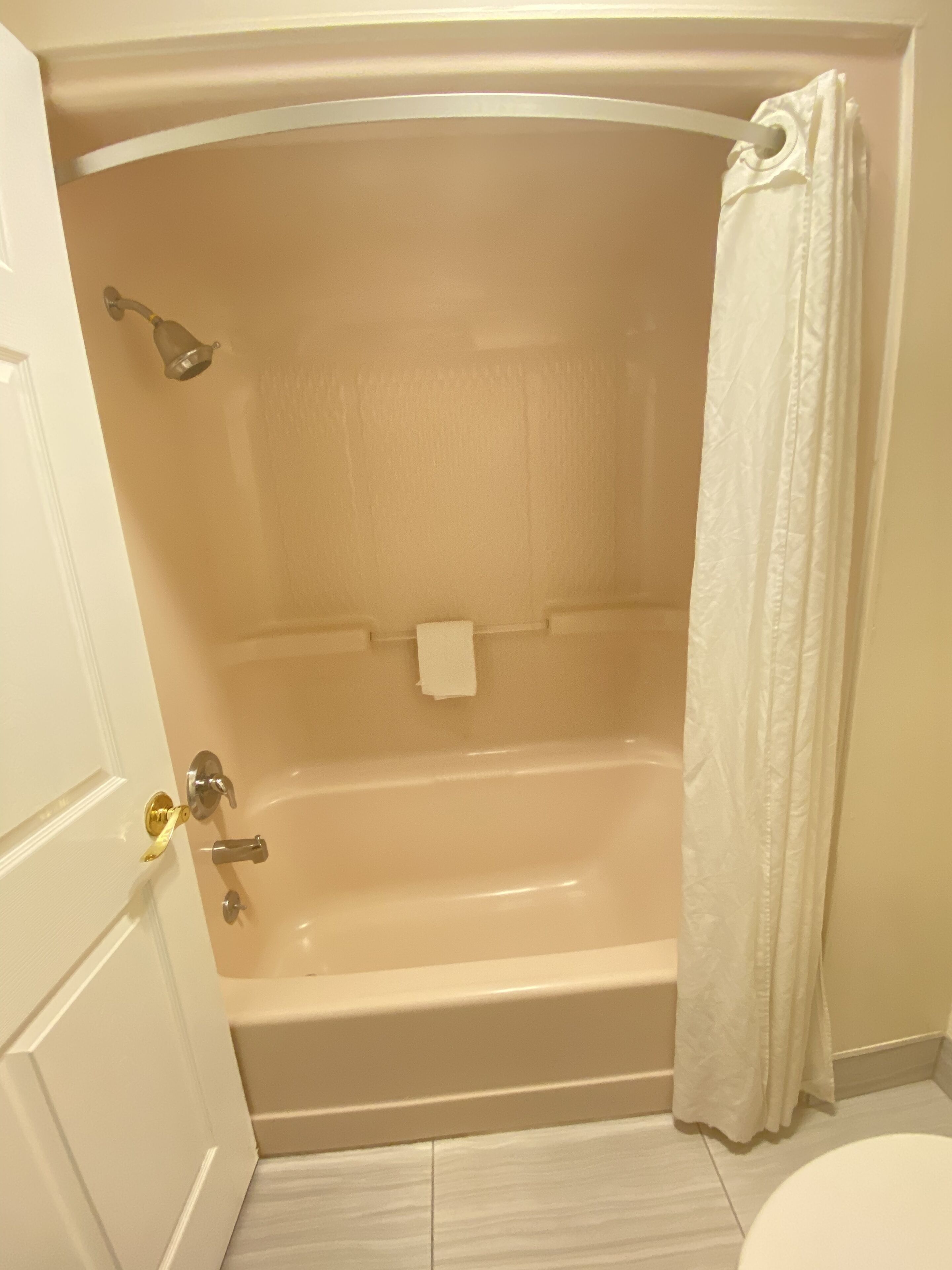 A bathroom with a bathtub, toilet, and a shower curtain.