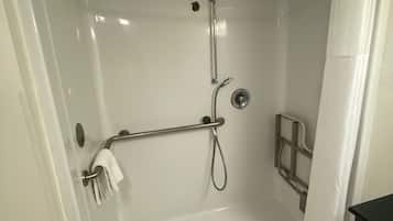 Doccia a filo pavimento con barra di sostegno, soffione manuale e scarico a pavimento.