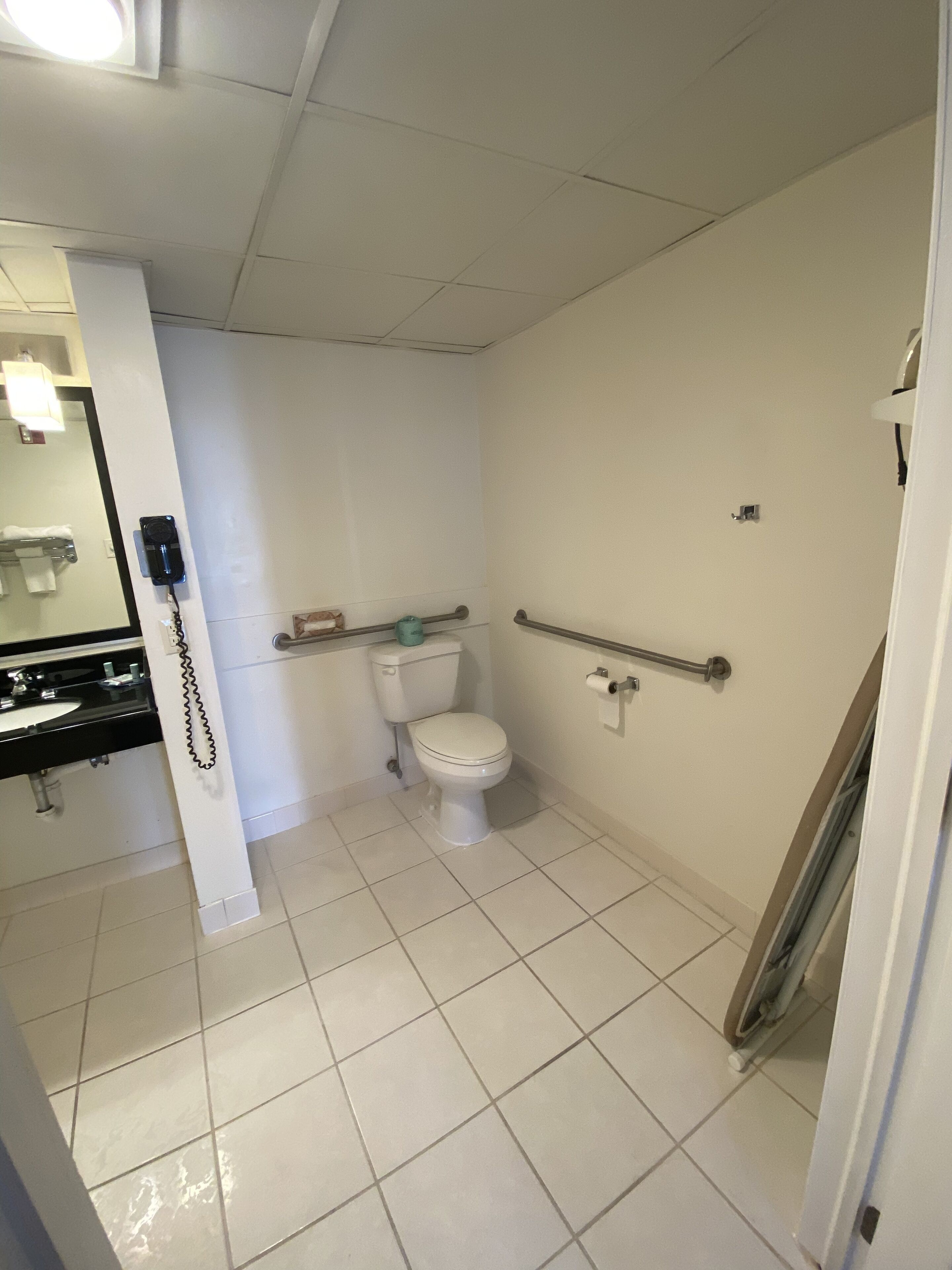 Un baño pequeño y limpio con inodoro, lavamanos y espejo.