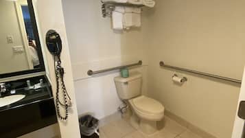 A small bathroom with a toilet, a sink, a towel rack, and a trash bin.