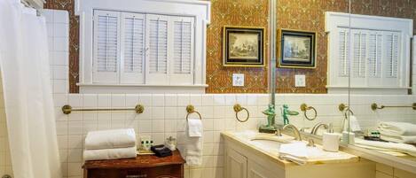 Une salle de bain équipée d’un meuble-lavabo, d’un lavabo et de toilettes. On y trouve des serviettes et des articles de toilette sur le meuble-lavabo.