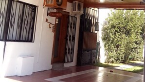 El exterior del Hotel Ventura Chiles, con un toldo de madera, un cartel y una entrada con portón.