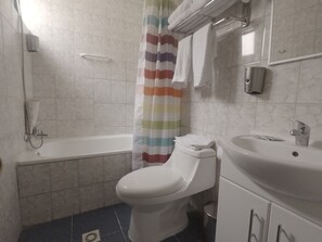 Une salle de bain avec une baignoire, des toilettes et un lavabo.