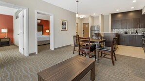 A hotel room with a dining area, kitchenette, and a bed. - Best Western Plus Merritt Hotel (Merritt)