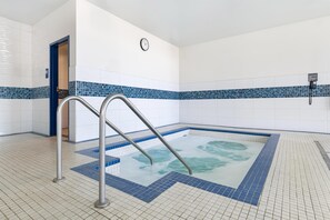 A swimming pool with a clock on the wall, a telephone, and a blue-tiled border. - Best Western Plus Merritt Hotel (Merritt)