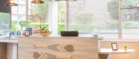Una mesa de recepción con elegantes tiradores con forma de remo, un frutero y una planta en maceta.