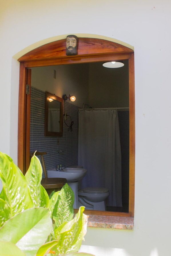 Un baño con un arco de madera, un lavabo, un inodoro y una cortina de ducha.