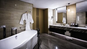 Ein modernes Badezimmer mit einer großen Badewanne, einem Doppelwaschtisch und einem großen Spiegel.