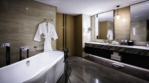 A modern bathroom with a large bathtub, a double sink vanity, and a large mirror. - Holiday Inn Baoji Central by IHG (Baoji)