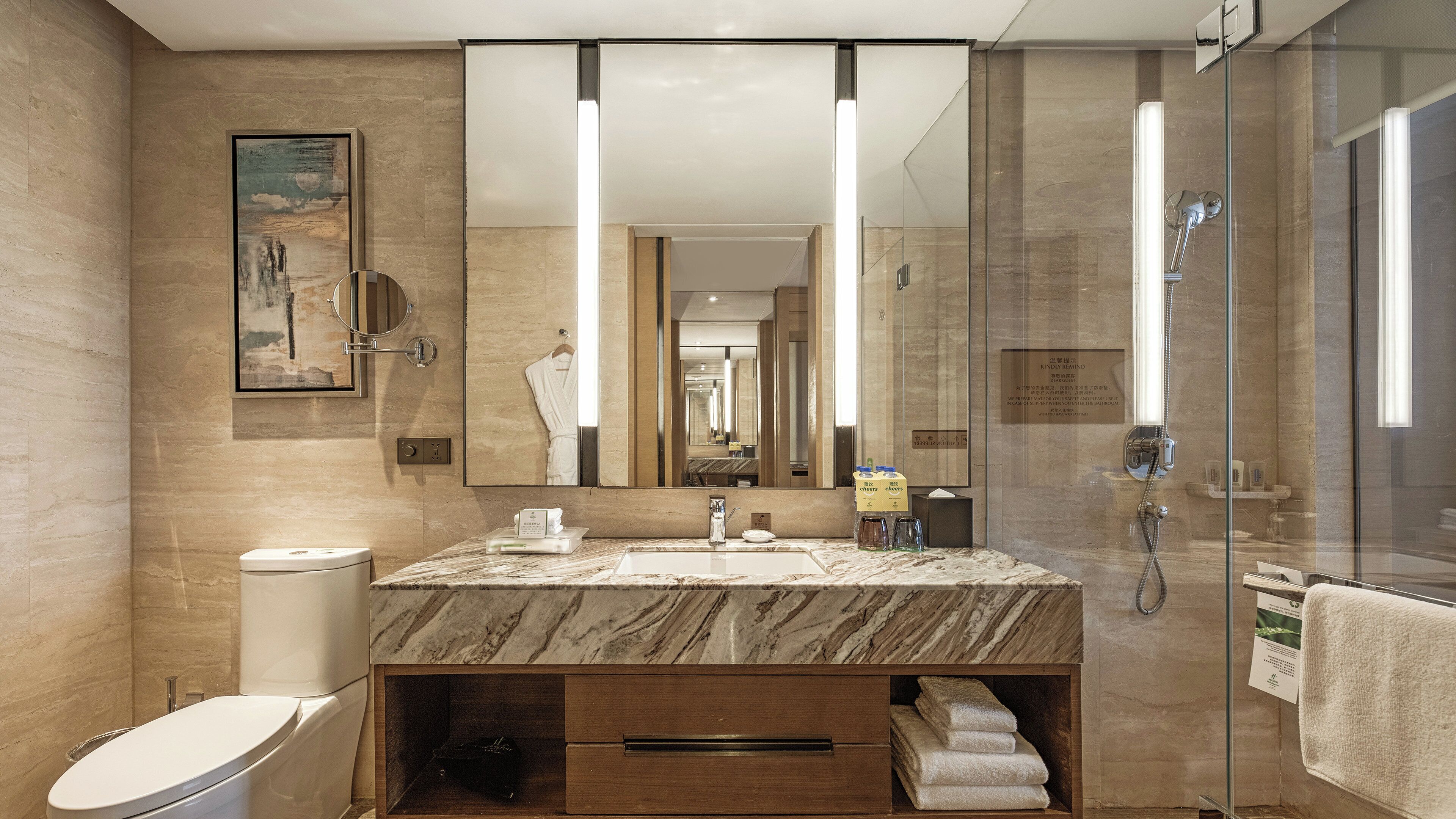 Un baño moderno con lavamanos de mármol, un espejo grande, cabina de ducha de vidrio y un inodoro.