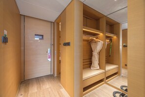 A hotel room with a wooden wardrobe, a mirror, and a bench. - Holiday Inn Baoji Central by IHG (Baoji)