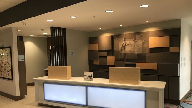 En receptionsdisk med et moderne design, med en lys træfinish og oplyste paneler.