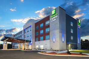 Un hôtel Holiday Inn Express & Suites au design moderne, avec une façade en briques et de nombreuses fenêtres.