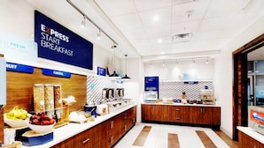 Un espace moderne dédié au petit-déjeuner, agrémenté d'une enseigne indiquant « PETIT-DÉJEUNER EXPRESS », proposant une variété d'aliments et présentant une disposition propre et bien organisée.