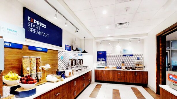 Een moderne ontbijtruimte met een bord waarop 'EXPRESS START BREAKFAST' staat, met diverse etenswaren en een nette, georganiseerde indeling.
