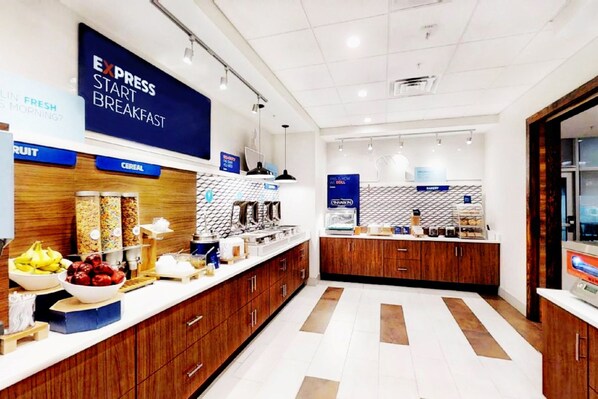 A modern breakfast area with a sign reading "EXPRESS START BREAKFAST," featuring a variety of food items and a clean, organized layout.