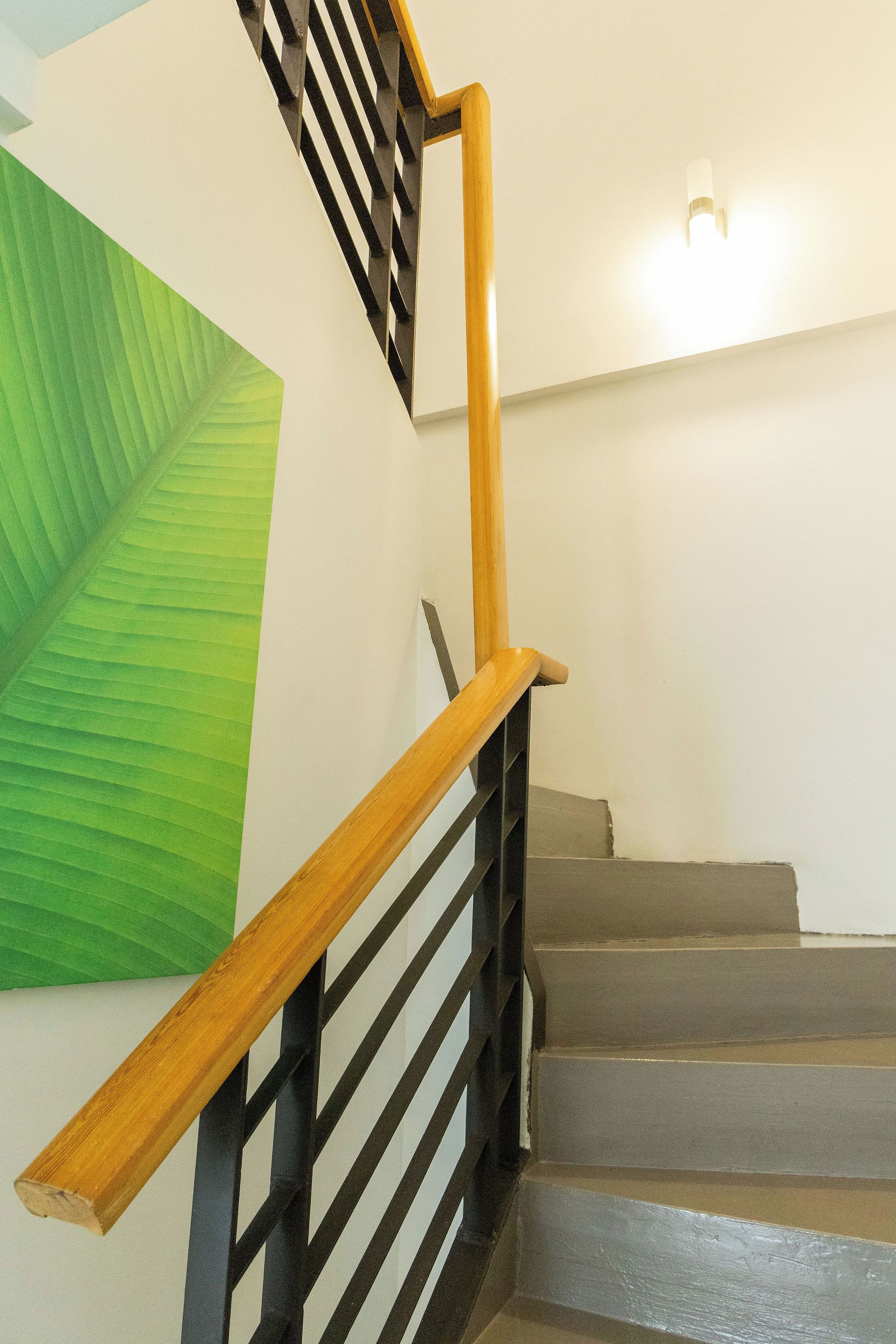 A staircase with wooden handrails and black metal balusters.