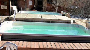 A swimming pool with a wooden deck and a plastic chair. - Mountainside 2 Bed 2 Bath (Frisco)