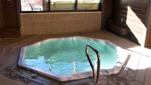 A hot tub with a wooden deck and a window view. - Mountainside 2 Bed 2 Bath (Frisco)
