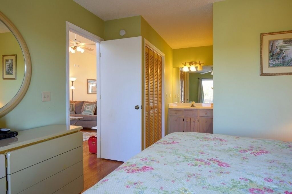 Ein Schlafzimmer mit Bett, Kommode und einer Tür zum Badezimmer.