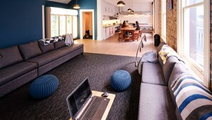 A modern living room with a sofa, a dining table, and a laptop on a wooden table. - Haka House Auckland K’ Road (Auckland)