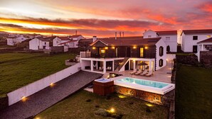 A two-story house with a swimming pool and outdoor seating area.
