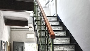 A staircase with a stone-like design, a wooden handrail, and a metal railing. - Torre Alpicella Holiday Home, a scenic escape into nature and relaxation! (Diano Marina)