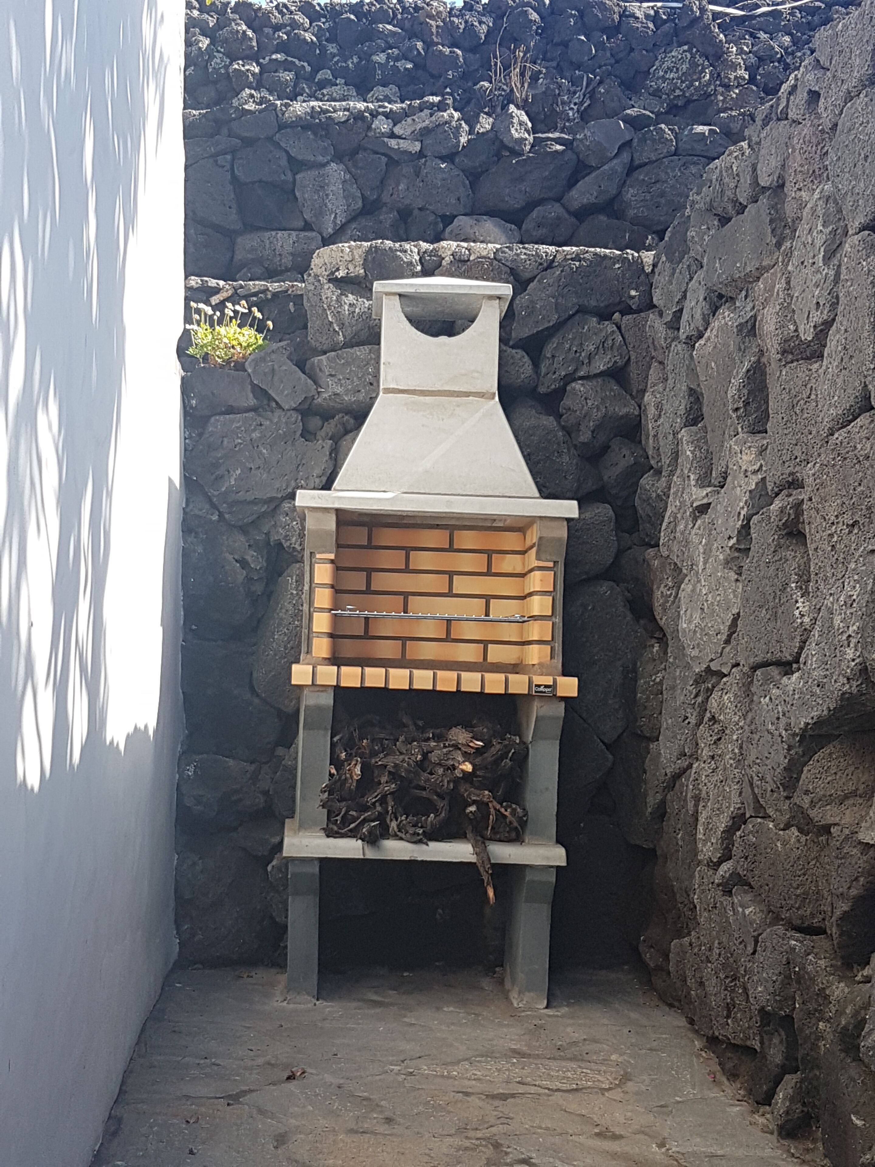 A stone wall with a brick-built outdoor oven.