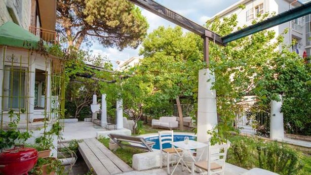 Patio con piscina, mobiliario exterior y una pérgola.