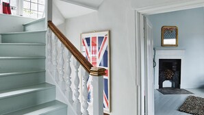 A staircase with white balusters and a wooden handrail, leading to a room with a fireplace and a framed picture on the wall. - Outstanding historic townhouse in city centre next to York Minster (sleeps 2-8) (York)
