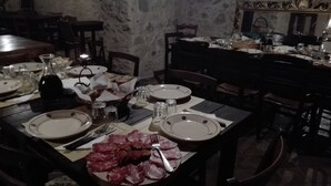 A dining table set with plates, cutlery, salt and pepper shakers, a bottle, and a basket of bread. - Penthouse with Panoramic Veranda immersed in Nature, a stone's throw from the Ionian Sea (Badolato Marina)