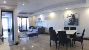 Un salon moderne comprenant un coin repas, un canapé, une table basse et un tableau accroché au mur.