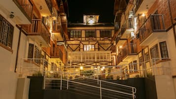 Un immeuble à plusieurs étages doté d’une cour intérieure, avec un escalier menant aux étages supérieurs.