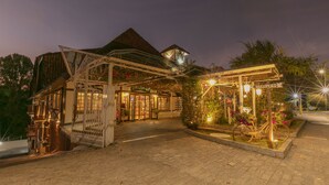 L’entrée d’un hôtel, avec un passage couvert, un espace d’accueil et un vélo garé à l’extérieur.