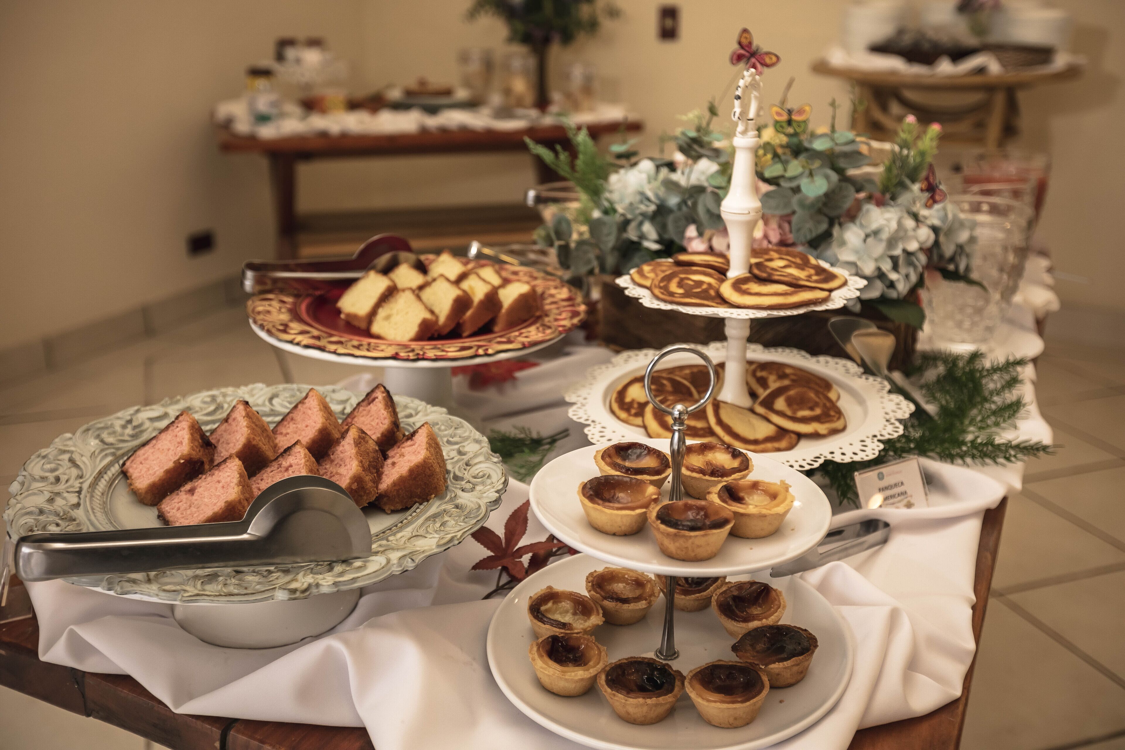A buffet table with various baked goods including bread, pastries, and tarts.