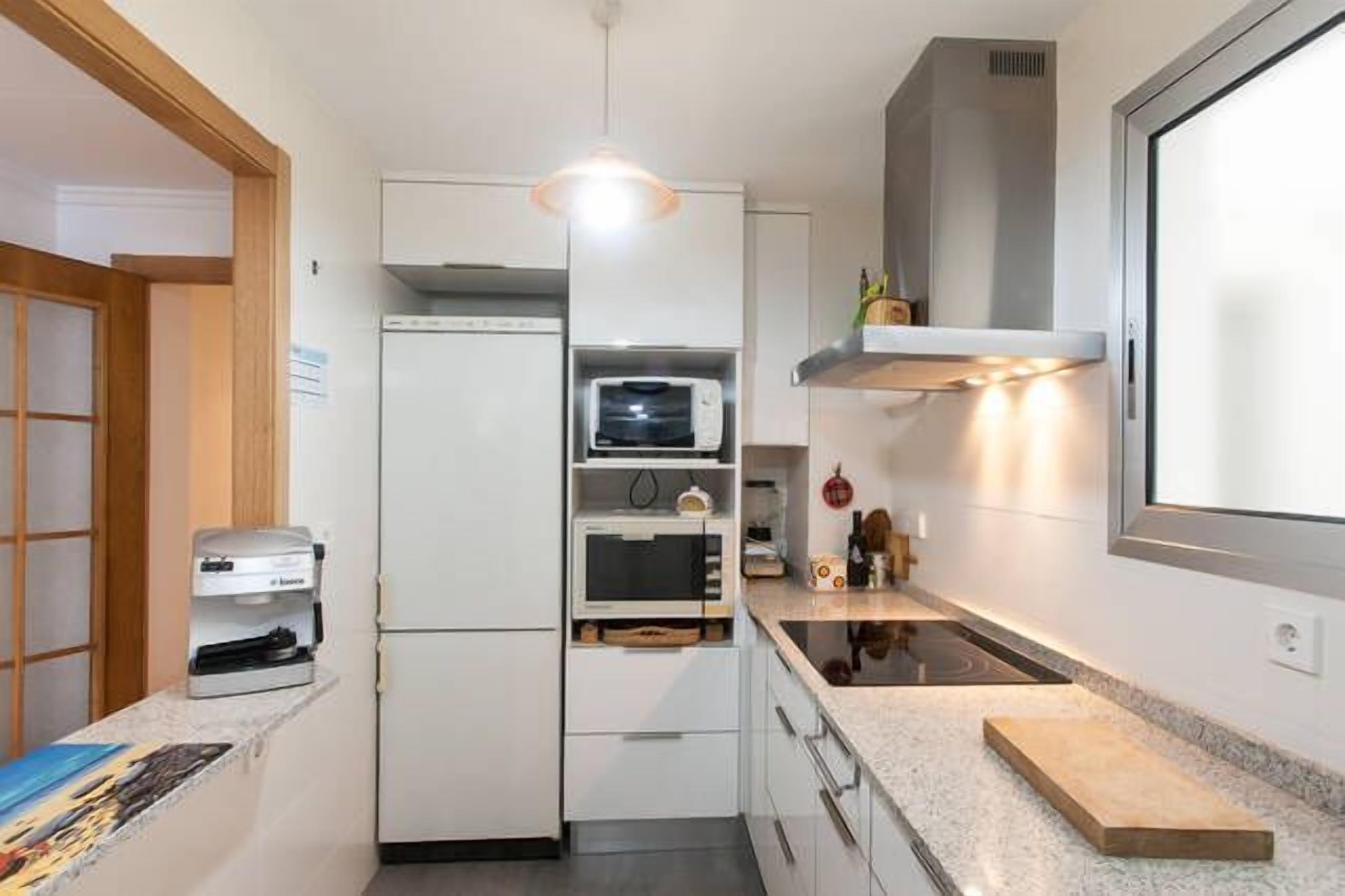 A compact kitchen with a built-in oven, microwave, and a small countertop.
