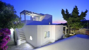 Een modern huis met een uniek architectonisch ontwerp, met een opvallende trap en een overdekt terras.