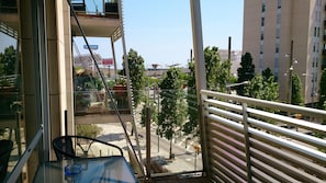 Enjoy the city view from this balcony with a clear view of the surrounding buildings and greenery.