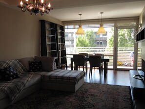 Relax in this inviting living space with a comfortable sofa, bookshelf, and dining area.