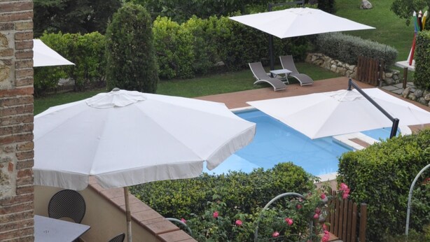 A patio with a pool, outdoor furniture, and umbrellas. - Apartment for 6 with 3 rooms near San Gimignano and Volterra. (montaione)