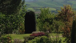 A view of a lush green landscape with rolling hills and a distant building. - Apartment for 6 with 3 rooms near San Gimignano and Volterra. (montaione)