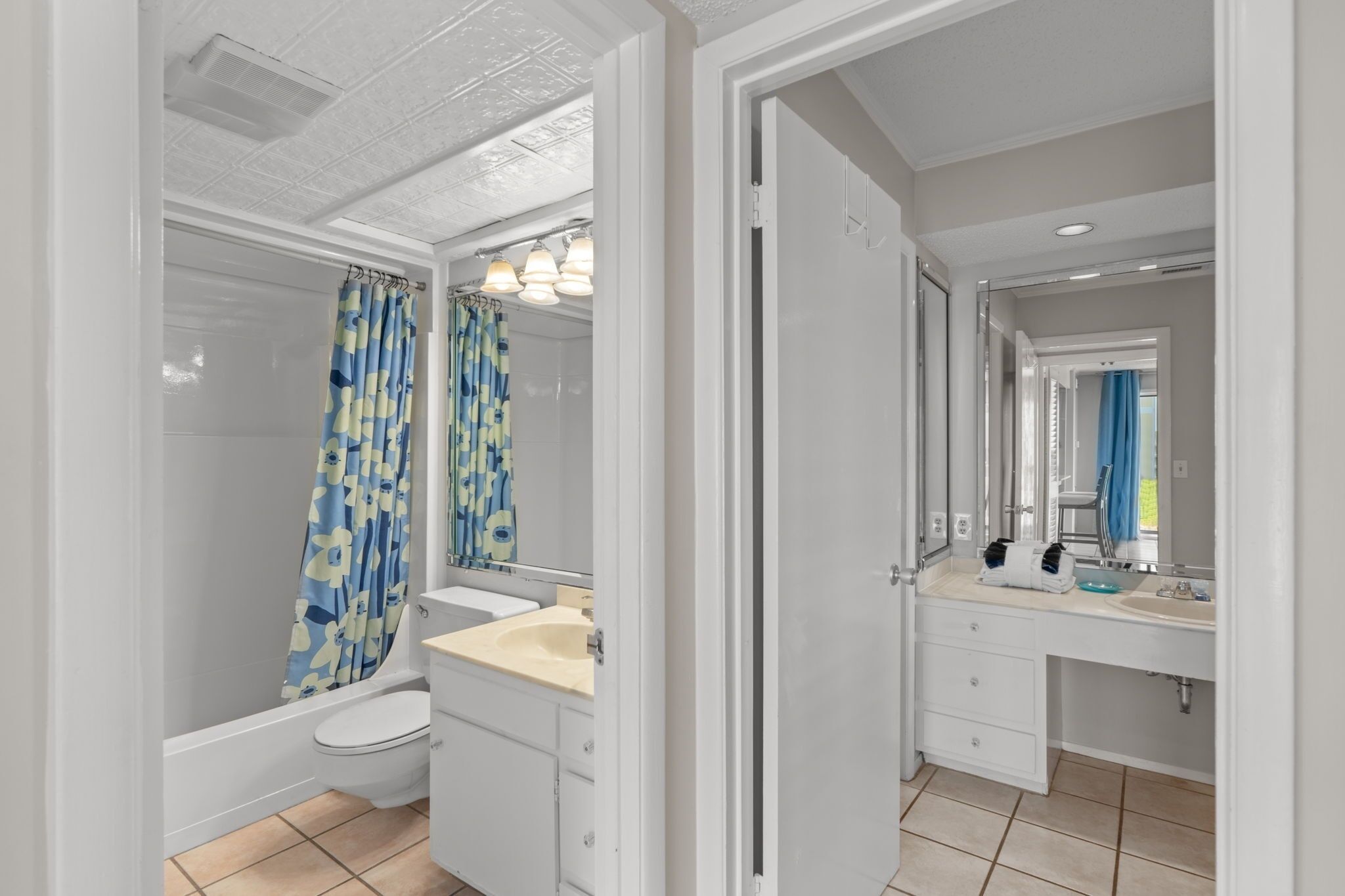 A bathroom with a toilet, sink, and shower curtain.