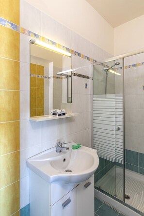 Huis | Badkamer | Een douche, handdoeken, shampoo, toiletpapier