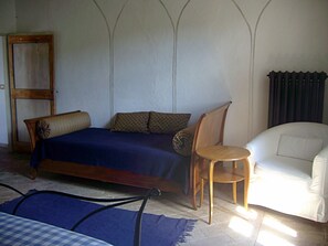 Une pièce comprenant un lit, une chaise et un canapé.