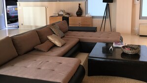 A modern living room with a sectional sofa, a coffee table, and a floor lamp.
